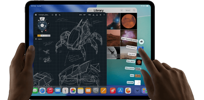 Asztrofekete iPad Pro, a felhasználó bal kézzel tartja a készüléket, jobb kézzel pedig mutató mozdulattal kezeli
      a megnyitott alkalmazásablakokat, melyek között megjelenik egy rajzolóapp vázlatos gépészeti tervekkel, fotókönyvtár bolygókkal
      és az űrről készült képekkel, valamint a Letöltések mappa fájljai legyezőszerűen kitárva